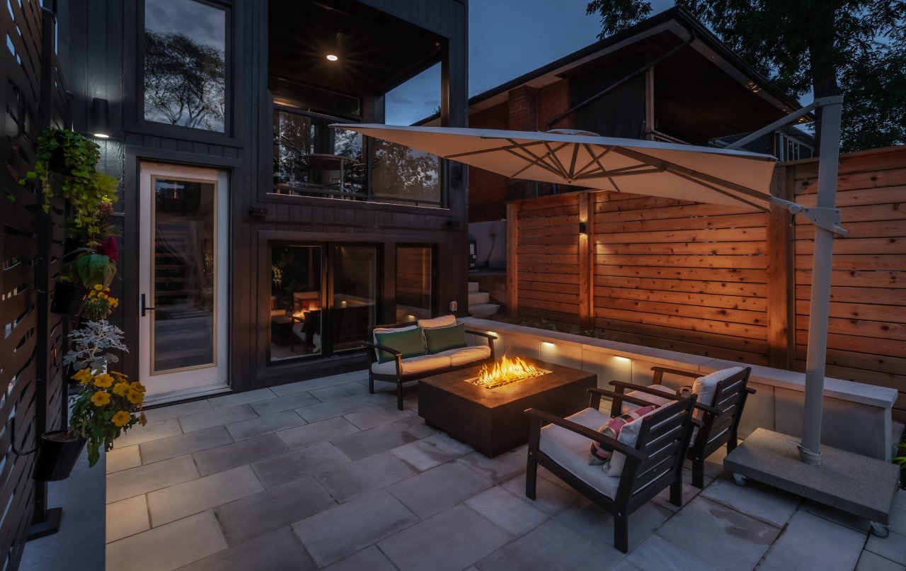 Backyard with a firepit and outdoor seating at dusk.